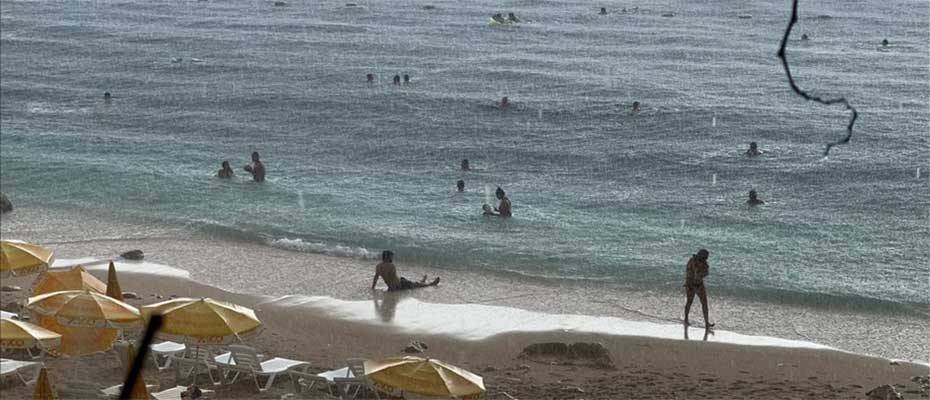 Antalya'da yağmura aldırış etmeyen turistlerin deniz keyfi